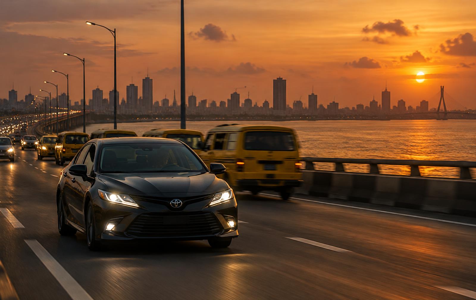 A car crossing Third Mainland Bridge at sunset with the Lagos skyline behind